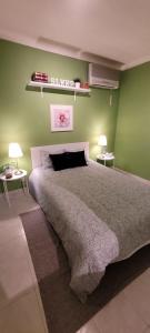 阿尔布费拉Jardins da Falesia的一间卧室设有一张带绿色墙壁的大床