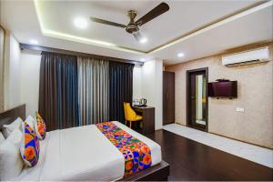 加尔各答FabHotel Prime Kzar Corporate的一间卧室配有一张床、一张书桌和一台电视。