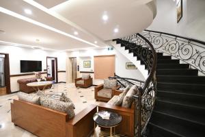 伊斯兰堡Royal Regency Hotel的一间带螺旋楼梯的客厅和一间客厅。