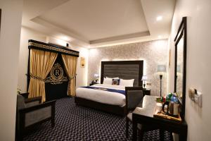 伊斯兰堡Royal Regency Hotel的一间卧室配有一张床、一把椅子和一张书桌