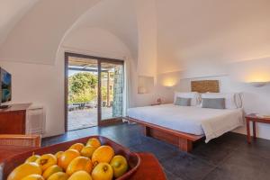 潘泰莱里亚Pantelleria Dream Resort的一间卧室配有一张床和一碗水果