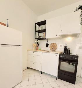德累斯顿Gemütliches helles Appartement的厨房配有黑炉和白色橱柜。