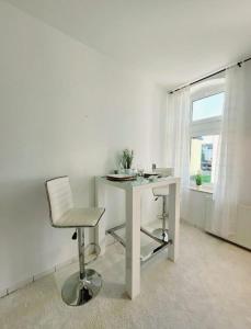 德累斯顿Gemütliches helles Appartement的窗户客房内的白色桌子和椅子