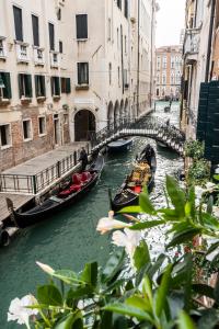 威尼斯Giò&Giò Venice B&B的两座缆车在城市的运河上,有建筑物