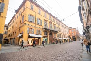 摩德纳Modena Centro Junior Suite的一群人沿着街道走着,街道上有许多建筑
