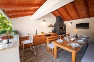 米利尼Luxury Vila Divina-Exceptional privacy的厨房配有木桌和炉灶。