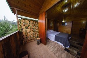 坎波斯杜若尔当Cabanas Capivari Lodge的小木屋内一间卧室,配有一张床