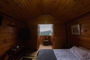 坎波斯杜若尔当Cabanas Capivari Lodge的木制客房内的一间卧室,配有一张床