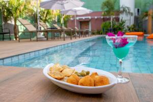 奥林匹亚利里奥阿瓜酒店的游泳池畔的桌子上放着一碗食物和饮料