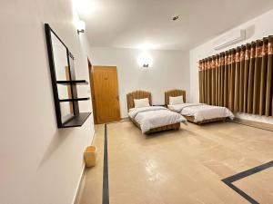 拉瓦尔品第Islamabad Travelodge Guest House的一间卧室设有两张床,墙上设有一面镜子