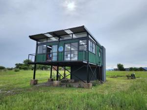 布里茨Balloon View Country Cottage的绿色建筑,在田野上放上时钟