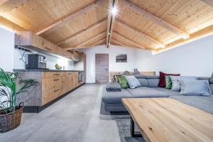 伦格里斯Alpenrose Ferienwohnungen的带沙发和木制天花板的客厅