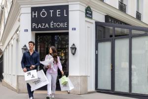 巴黎Hôtel Plaza Étoile的男人和女人在街上走,带着购物袋