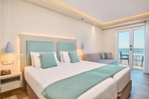 蒂锡利维Tsilivi Beach Hotel Zakynthos的一间带大床的卧室和一个阳台