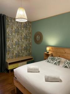 圣艾尼昂La Maison des lilas, 5 mn de Beauval的卧室配有一张白色大床和吊灯。