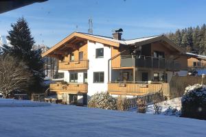 萨菲登安斯泰内嫩米尔Appartement Kollingwald的雪中带栅栏的房子