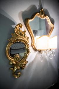 威尼斯Giò&Giò Venice B&B的挂在墙上的金色镜子,灯
