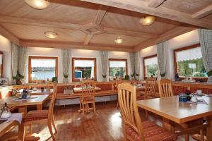 柯尼希斯湖畔舍瑙Landhaus Maltermoos的餐厅设有木桌、椅子和窗户。