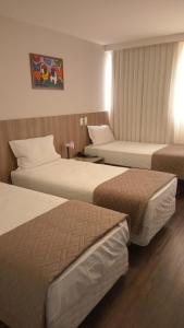 伊达贾伊Hotel 7 Itajaí的一间酒店客房,房间内设有两张床