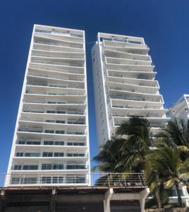 通苏帕Vacaciones Playa Azul的两座高大的建筑,前面有棕榈树