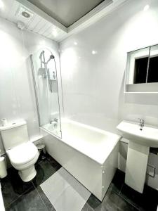 爱丁堡Loft apartment in Joppa的白色的浴室设有卫生间和水槽。