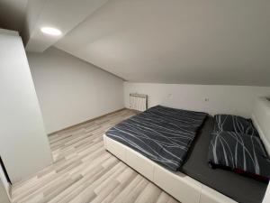 奥西耶克Golden House的一间卧室设有一张大床,铺有木地板。