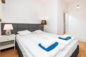 华沙Apartament Polna by Your Freedom的卧室配有白色大床和蓝色毛巾
