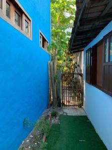 卡拉伊瓦Casa da Lua no centro da Vila de Caraíva ao lado da Igreja de Caraíva的蓝色房子,有门和绿草