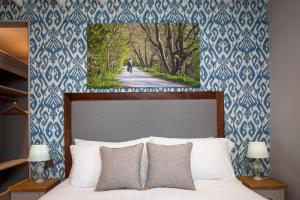 温斯康比伍德伯勒酒店的一间卧室配有一张蓝色和白色壁纸的床