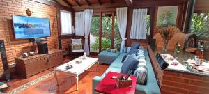 伊泰帕瓦Casa Serrana, 4 quartos com ar e piscina aquecida em meio à Natureza de Itaipava的带沙发和电视的客厅