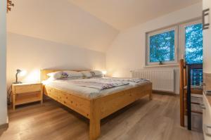 博希尼Apartment Ticar的一间卧室设有木床和2个窗户。