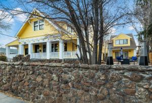 弗拉格斯塔夫Bespoke Inn Flagstaff的一座黄色的房子,有石墙