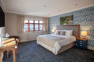温斯康比伍德伯勒酒店的一间卧室配有一张床、一张书桌和一个窗户。