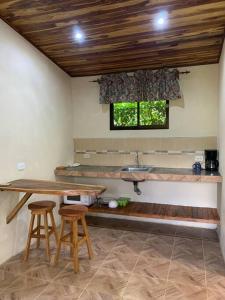 圣克鲁斯Miniapartamento el Guanacaste, cerca Tamarindo的一间设有一张桌子、两张凳子和窗户的房间