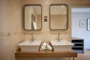 温斯康比伍德伯勒酒店的浴室设有2个水槽和2面镜子