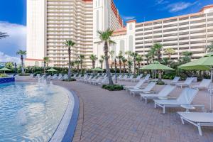巴拿马城海滩Spacious Resort Condo with Breathtaking Gulf Views! by Dolce Vita Getaways PCB的游泳池旁的一排白色躺椅