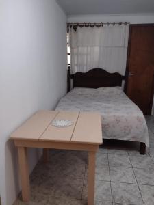 卡庞达卡诺阿Scotti's Suítes的一张桌子和一张床上的床上床,床上有西德西德西德
