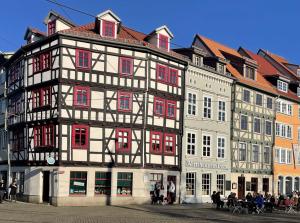 爱尔福特Appartement DOM II - Erfurt Domplatz的一座黑色和白色的大建筑,设有红色的窗户