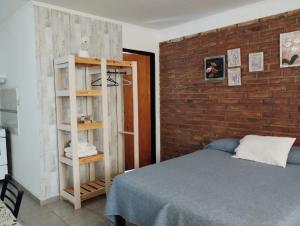 圣罗莎El Poblador的一间卧室设有一张床和砖墙