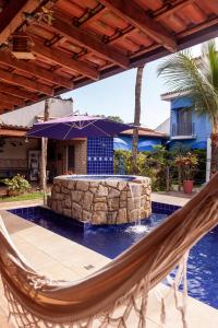 瓜鲁雅Pousada Canto Azul Guarujá的游泳池旁天井上的吊床