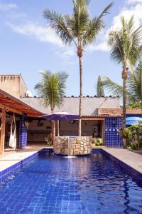 瓜鲁雅Pousada Canto Azul Guarujá的一座别墅前方的棕榈树游泳池