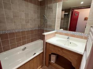 琴山朗勒堡Appartement Lanslebourg-Mont-Cenis, 3 pièces, 6 personnes - FR-1-508-256的带浴缸、水槽和镜子的浴室