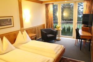 林茨Hotel Alhartinger Hof的酒店客房设有两张床、一张书桌和一个窗户。