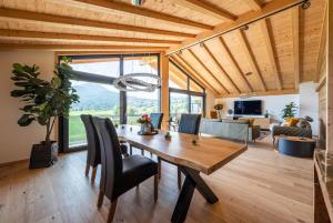 奥伯斯特多夫Alpine Lifestyle Lodge的一间带木桌和椅子的用餐室