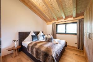奥伯斯特多夫Alpine Lifestyle Lodge的一间卧室设有一张带木制天花板的大床