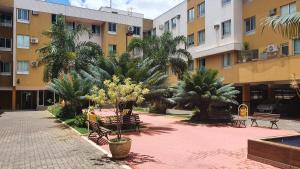 巴西利亚Ed. Boulevar Antares II的一座建筑前方的庭院,庭院内种植了长椅和棕榈树