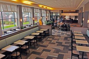 诺福克品质套房酒店赖湖特诺福克机场的一间带桌椅的餐厅和一间酒吧