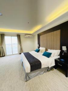 Sarat Abidahفندق وريف الشرق的大型酒店客房,配有一张带蓝色枕头的大床