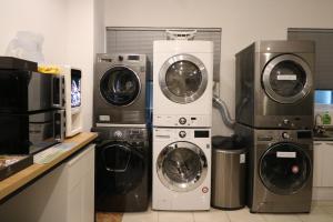 首尔The garden hotel的厨房配有3台洗衣机和干衣机