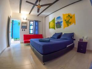 圣玛尔塔Dreamer Santa Marta的一间卧室配有蓝色的床和红色的沙发